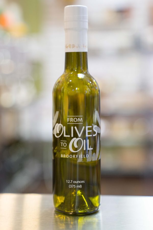 A bottle of olive oil sitting on top of a table.