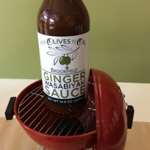 A bottle of beer is sitting on the grill.