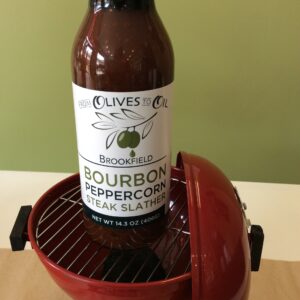 A bottle of bourbon peppercorn ale is sitting in an electric grill.
