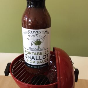 A bottle of sauce sitting in an electric grill.