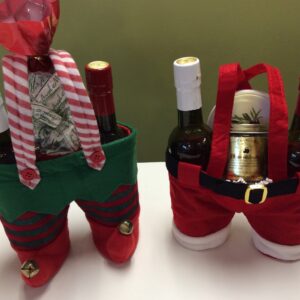 Two christmas themed wine holders are sitting on a table.
