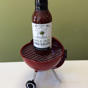 A bottle of apple jack bbq sauce on top of an electric grill.