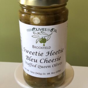A jar of queen olives on a plate.
